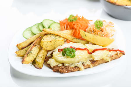 Hawaiian cutlet with baked potatoes and a bouquet of saladsの写真素材