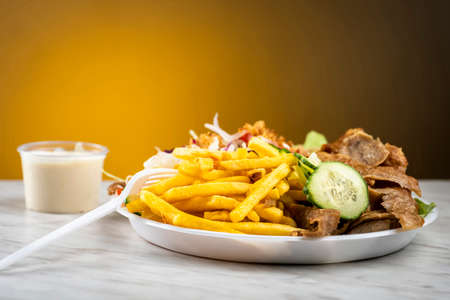 kebab meat with fries and vegetables - takeaway