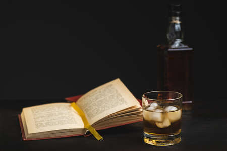 a glass of whiskey and a good book - time to relax - photo in retro styleの写真素材