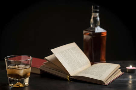 a glass of whiskey and a good book - time to relax - photo in retro styleの写真素材
