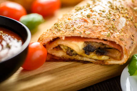 Pizza stromboli on a wooden backgroundの写真素材