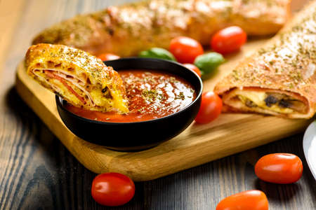 Pizza stromboli on a wooden backgroundの写真素材