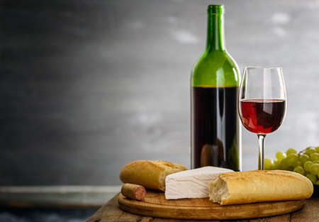 A small snack - baguette, cheese and wine in the atmospheric interior of an old wineryの写真素材