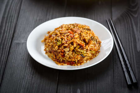 rice with vegetables in sweet and sour sauce on wooden tableの写真素材