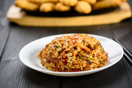 rice with vegetables in sweet and sour sauce on wooden tableの写真素材