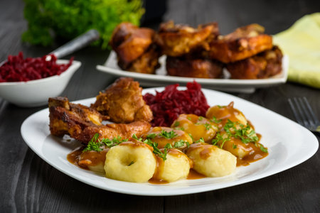 Ribs in honey and Silesian dumplings served with beetroot and sauceの写真素材