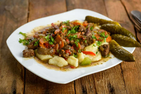 potato dumplings with goulash and cucumberの写真素材