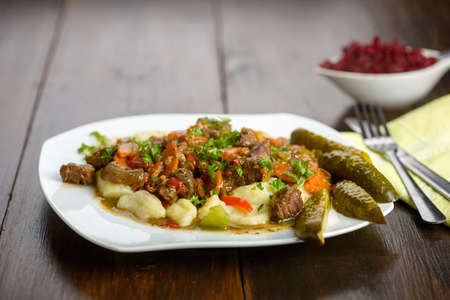 potato dumplings with goulash and cucumberの写真素材