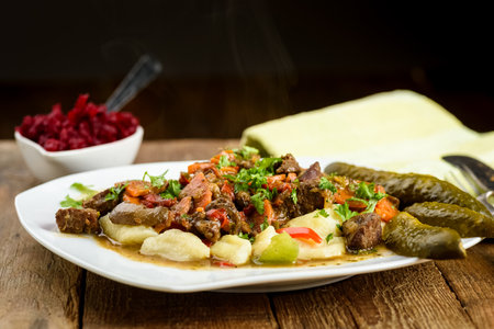 potato dumplings with goulash and cucumberの写真素材