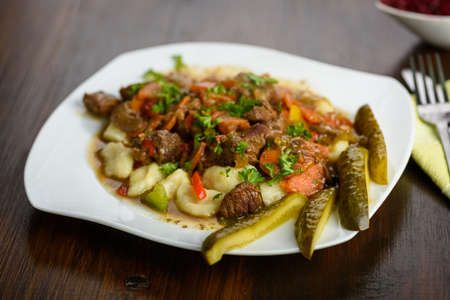 potato dumplings with goulash and cucumberの写真素材