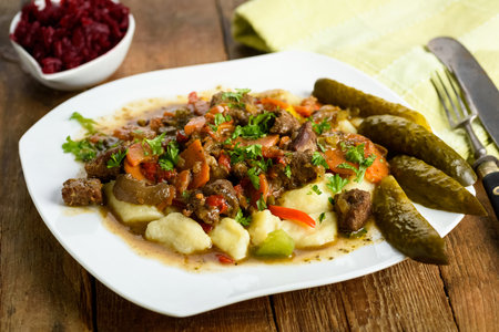potato dumplings with goulash and cucumberの写真素材