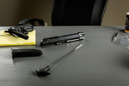 Cleaning the gun is an important part of ASG games. A working weapon is an element of a successful game. Disassembled pistol on a wooden table.の写真素材