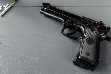 Cleaning the gun is an important part of ASG games. A working weapon is an element of a successful game. Disassembled pistol on a wooden table.の写真素材