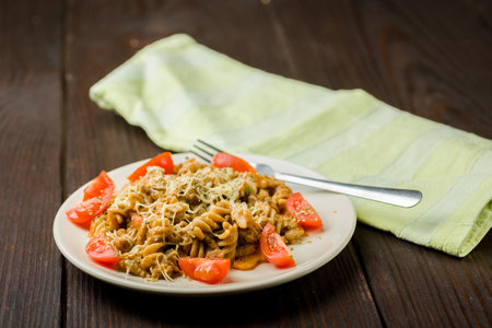 pasta with minced meat, tomato sauce and pieces of tomatoes on a wooden tableの写真素材