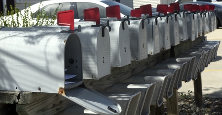Entire row of numbered standard US mailboxes have red flag raised の写真素材