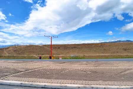 Empty road under construction with warning light on a busy day with blue sky.の写真素材