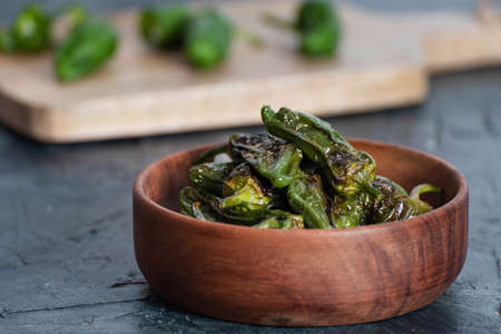 Padron peppers on wooden bowl. Typical spanish food. Healthy food. Traditional Spanish green...