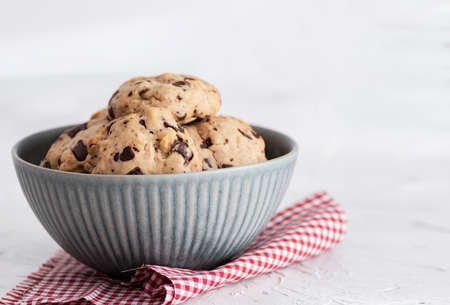 Homemade cookies with chocolate chips in bowl. White background.