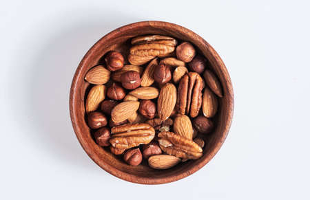 Mixed nuts in wooden bowl on white background. protein source. Isolated.