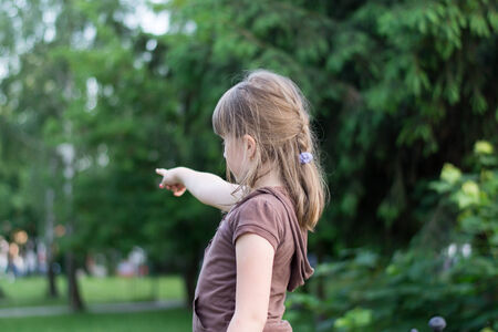 The girl turned and shows his hand in the direction ofの写真素材