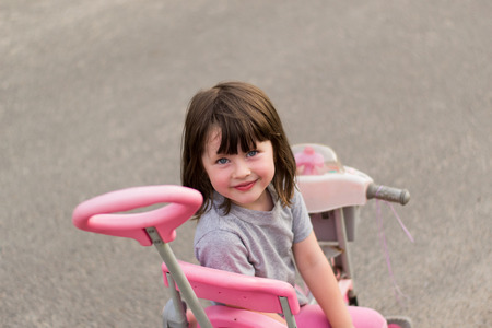 a little girl sitting on a bikeの写真素材