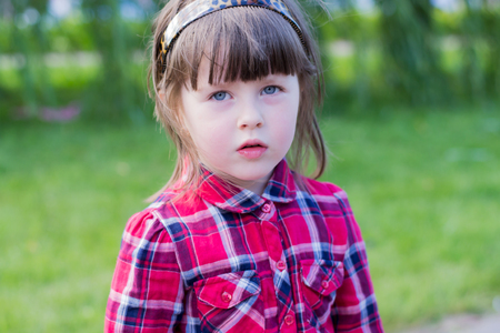 little girl crawls through the grass, outdoorsの写真素材
