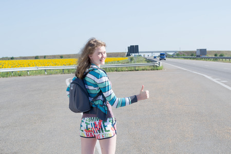 young girl with a backpack on his back, in the summer hitchhikingの写真素材