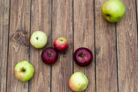 red apple and yellow apples on a wooden tableの写真素材