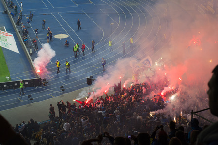 football fans celebrate victory with fireworks during a football match
