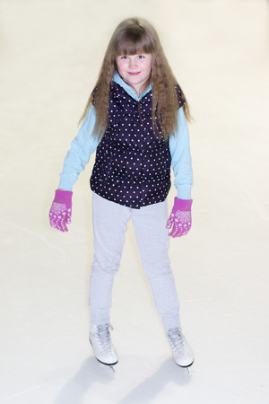 little girl without a hat with her hair in skates on iceの写真素材
