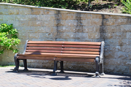 beautiful alley with benches in a small green park with shrubs and trees in urban areas