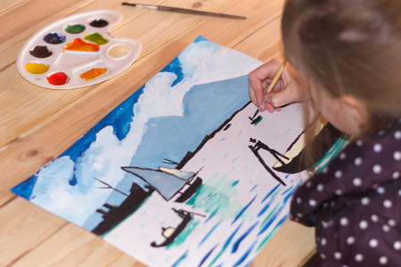 Girl draws fishermen in a boat on the water gouache on paper in warm colors