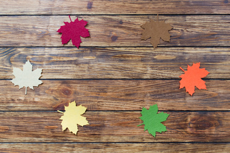 colorful decorative autumn leaves of felt on a wooden background