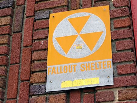 vintage fallout shelter sign attached to brick wallの写真素材