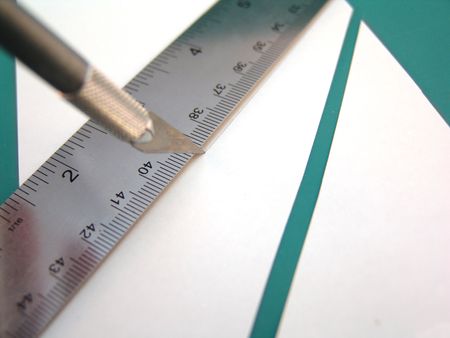 knife with ruler and white paper on green cutting surfaceの写真素材