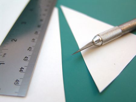 knife with ruler and white paper on green cutting surfaceの写真素材