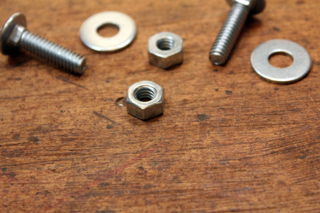 Nuts, bolts, and washers over wood background