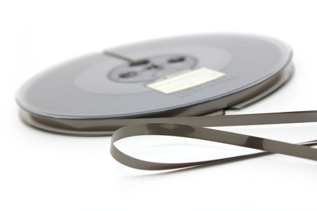 Reel-to-reel recording tape over white backgroundの写真素材