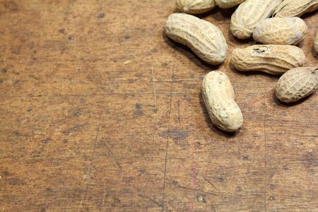 Small pile of peanuts in shells over wood backgroundの写真素材