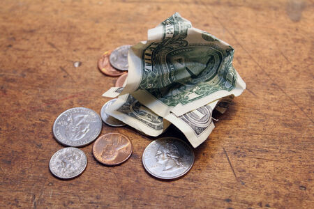 Pocket change dollars and cents on old wood の写真素材