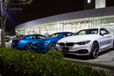 Vancouver BC, Canada - January 9, 2018: Office of official dealer BMW. BMW is a German automobile manufacturer specializing in high-performance and luxury cars. Night shot all is illuminated.のeditorial素材