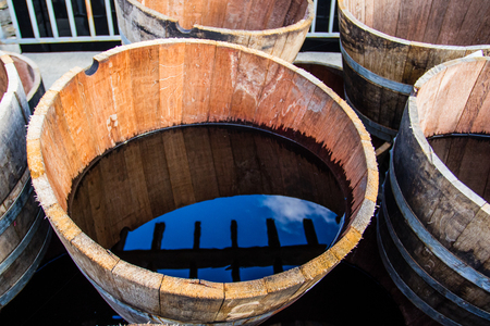 Old half barrels filled with water reflecting the surroundings.の写真素材