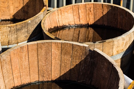 Old wooden half barrels. Ex wine casks having a second life to be used as decoration or as a flower planters.の写真素材