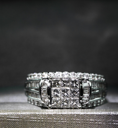 A diamond engagement ring in a box with glint/reflection. Shimmering princess-cut diamonds.の写真素材