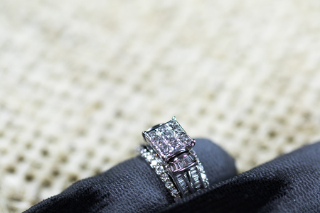 A diamond engagement ring in a box with glint/reflection. Shimmering princess-cut diamonds.の写真素材