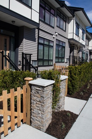 Brand new upscale townhomes in a Canadian neighbourhood. External facade of a row of colorful modern...