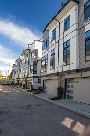 Brand new townhouse complex. Rows of townhomes side by side. External facade of a row of colorful...