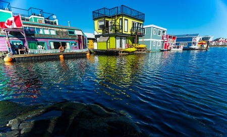 Floating Home Village colorful Houseboats Water Taxi Fisherman's Wharf Reflection Inner Harbor, Victoria British Columbia Canada Pacific Northwest. Area has floating homes, piers, restaurants.のeditorial素材