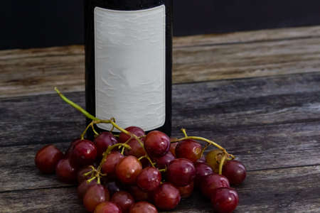 Wine Bottle with fruits on the side laid on wooden tableの写真素材