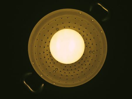 fluorescent lamp mounted in an aluminiun pasta colander (clipping path)の写真素材